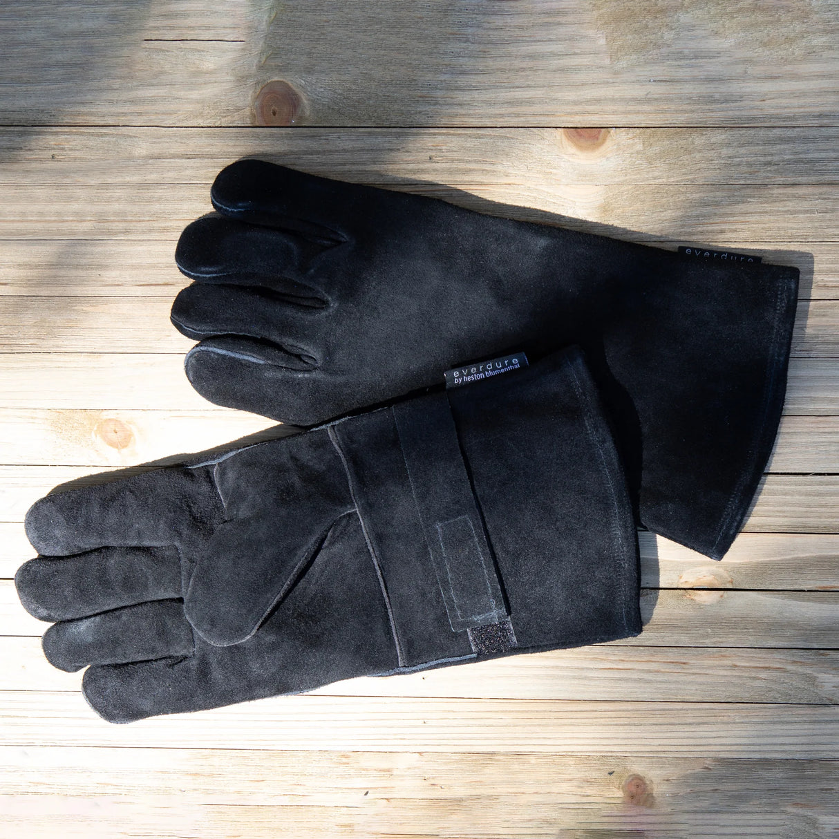 Pair of black gloves on a wooden surface
