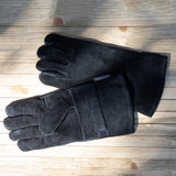 Pair of black gloves on a wooden surface