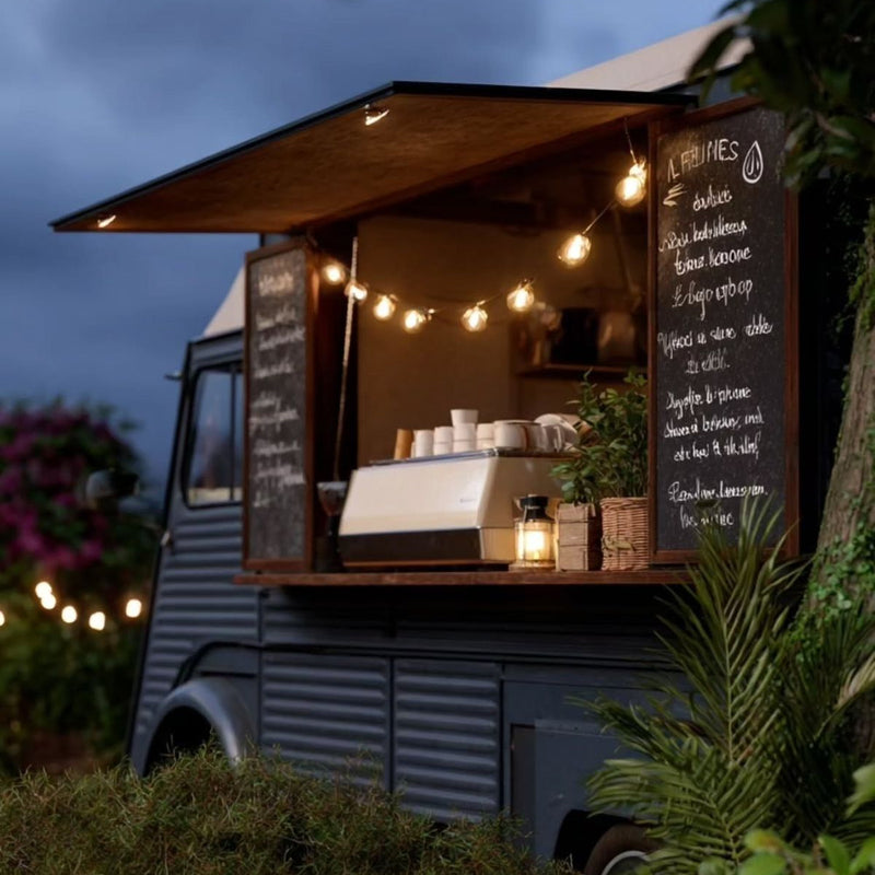 Food truck with outdoor lighting and a menu board in a garden setting